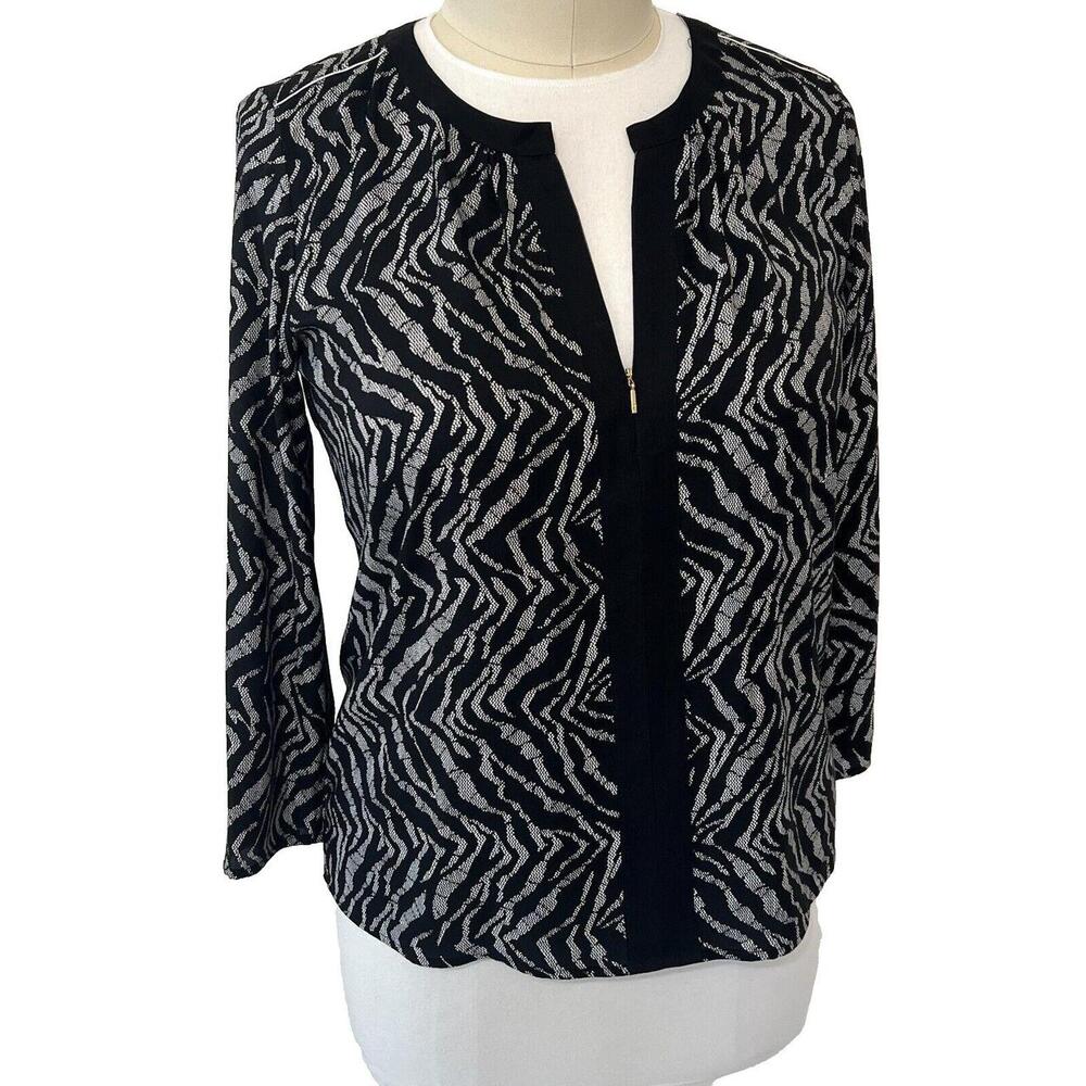 This Donna Karan blouse features an abstract zebra print design in black and whi